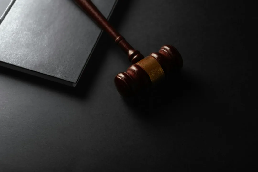 Судейский молоток рядом с книгой: суды, долги и залоги продавца видны в открытых реестрах до сделки